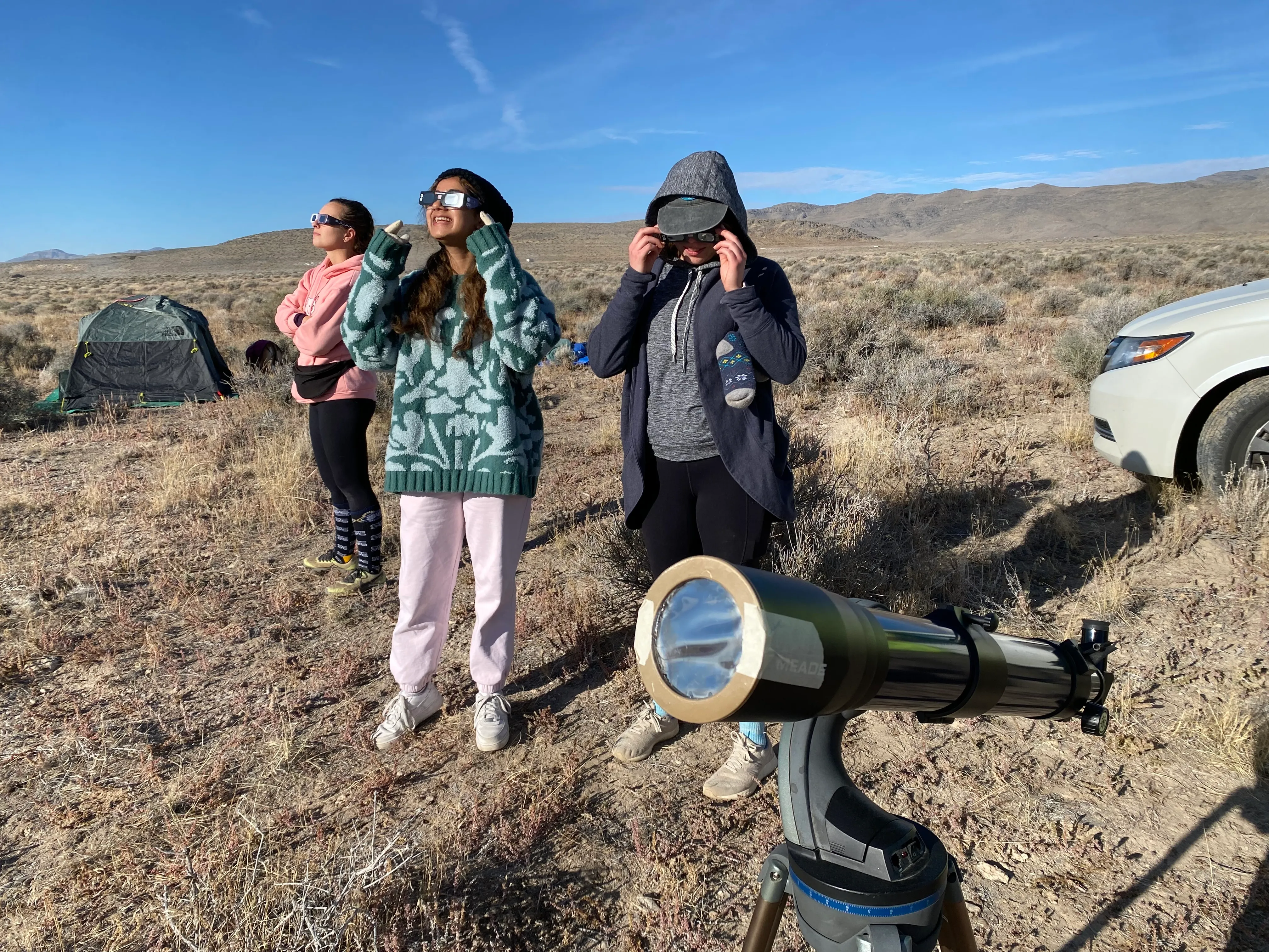 picture of girls looking at the eclipse through eclipse glasses